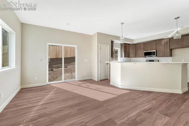 a view of a kitchen with wooden floor and electronic appliances