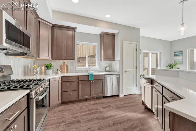 a kitchen with stainless steel appliances kitchen island granite countertop a stove a sink and a refrigerator