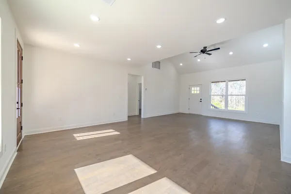 an empty room with windows and ceiling fan