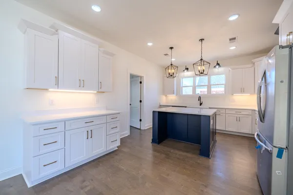 a kitchen with stainless steel appliances granite countertop a sink a stove and a refrigerator