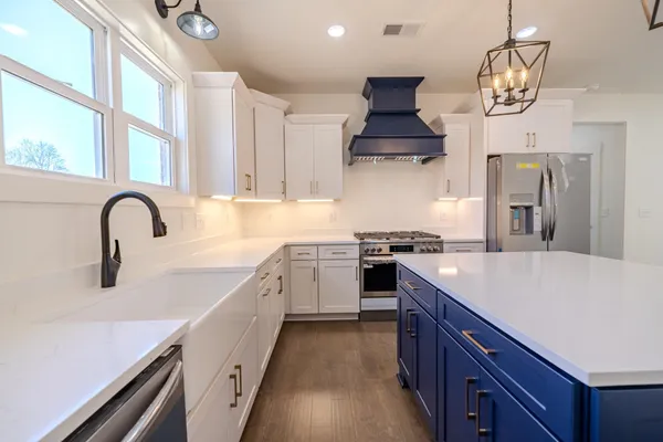 a kitchen with stainless steel appliances white cabinets and a stove