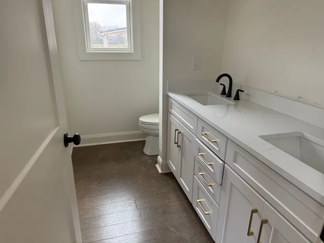 a bathroom with a double vanity sink and a toilet