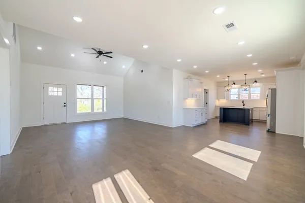 an empty room with a window and a ceiling fan