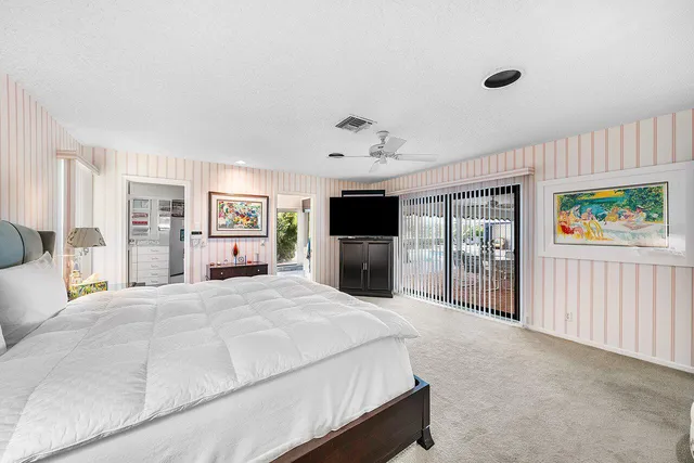 a large white kitchen with granite countertop a stove a sink and a large window