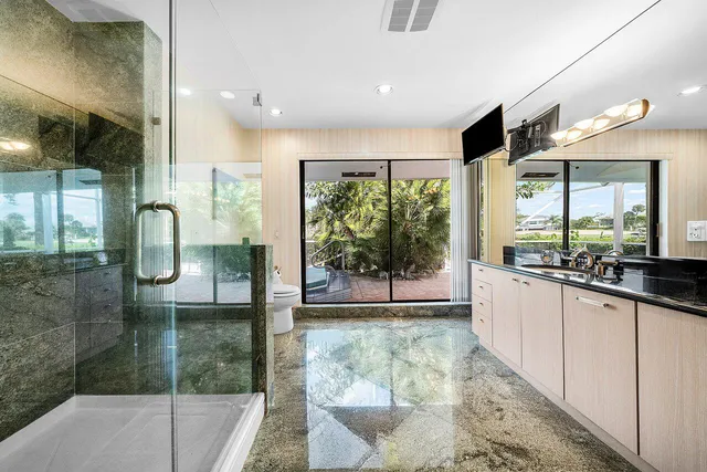 a bathroom with a granite countertop sink a toilet and mirror