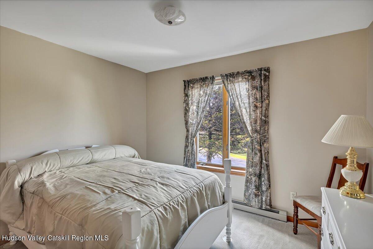 28 Hennett Road Valatie, NY 12184 - Photo 15 of 40 a bedroom with a bed and a chair