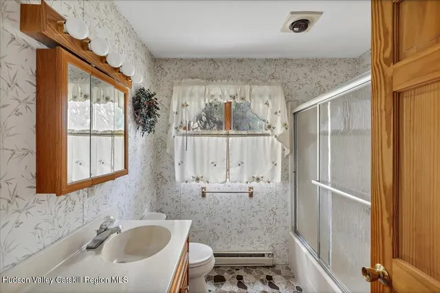 a bathroom with a granite countertop sink a toilet and shower