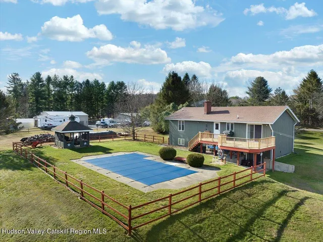 a view of a house with swimming pool and sitting area
