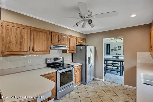 a kitchen with stainless steel appliances a refrigerator a stove a sink cabinets and a refrigerator