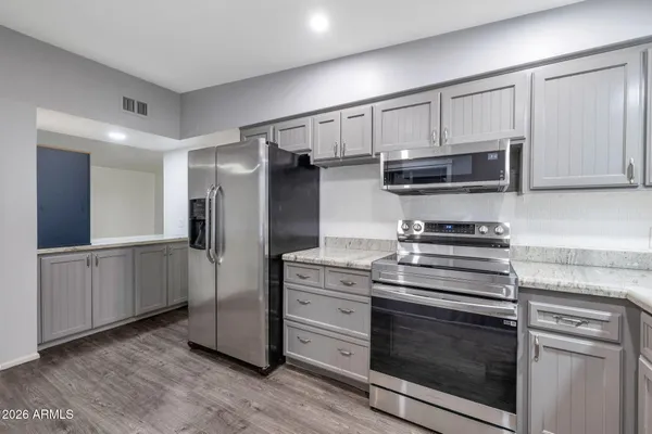 a kitchen with stainless steel appliances white cabinets and a stove top oven