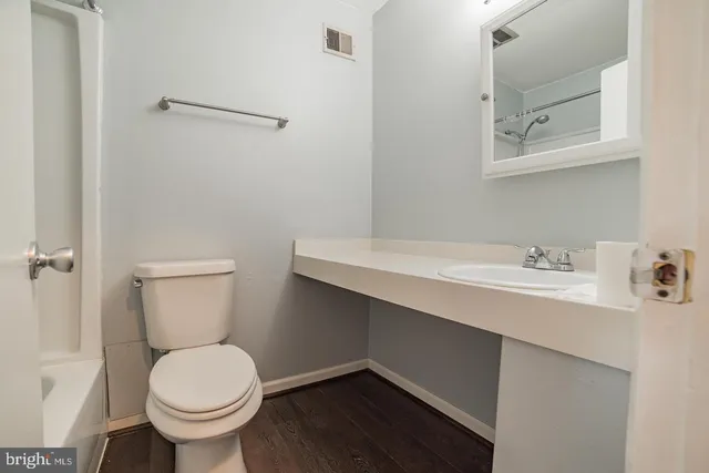 a bathroom with a sink toilet and a mirror