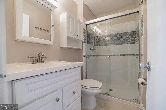 a bathroom with a sink a mirror a toilet and shower