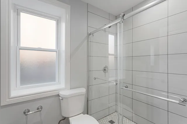 a bathroom with a toilet and a shower