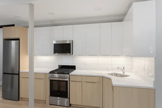 a kitchen with stainless steel appliances a stove microwave and sink