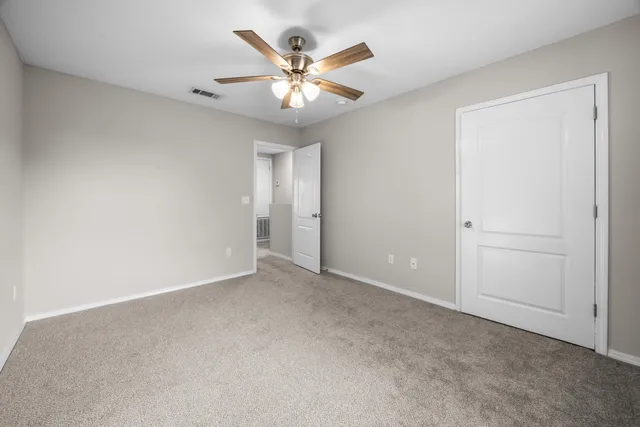an empty room with closet and windows