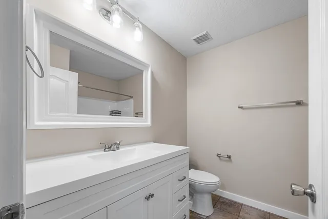 a bathroom with a sink a toilet and a mirror