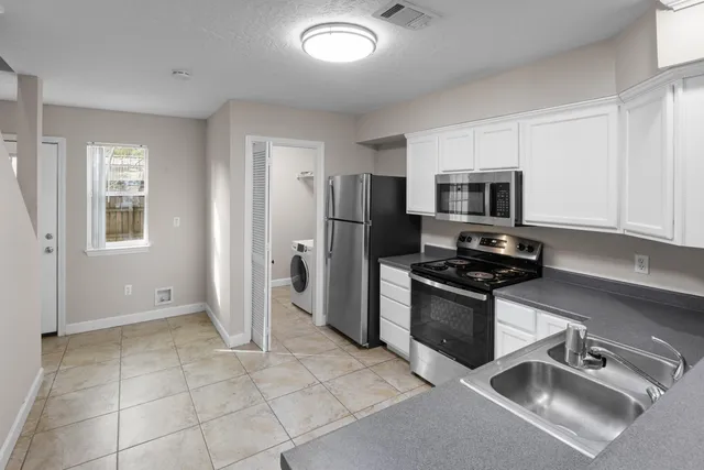 a kitchen with stainless steel appliances granite countertop a refrigerator and a stove top oven