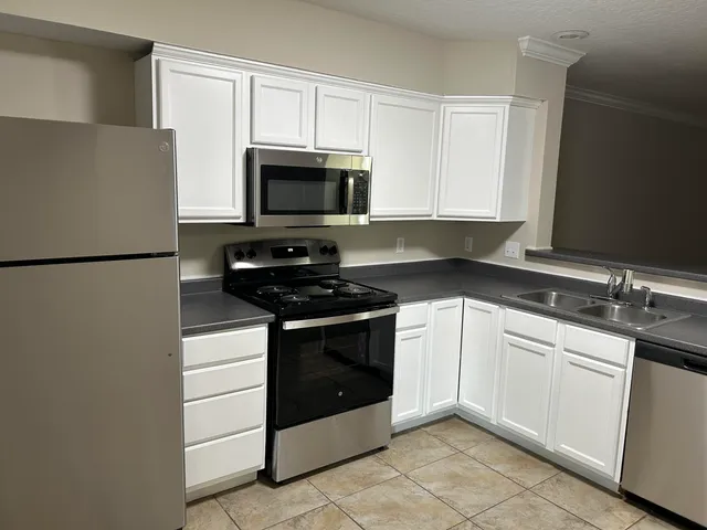 a kitchen with cabinets stainless steel appliances and sink