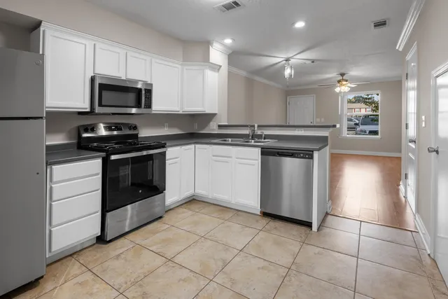 a kitchen with stainless steel appliances granite countertop a stove a sink and a microwave