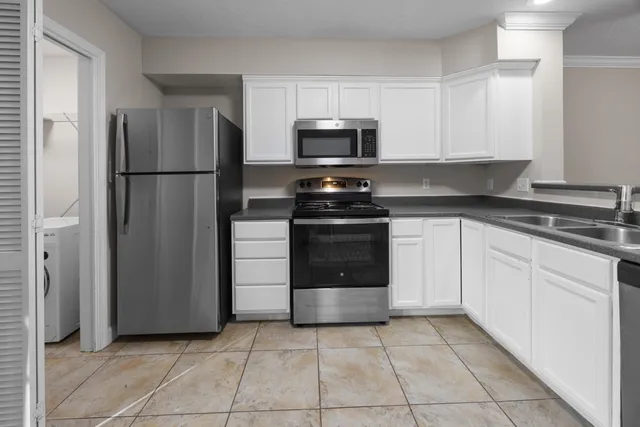 a kitchen with stainless steel appliances granite countertop a refrigerator and a sink