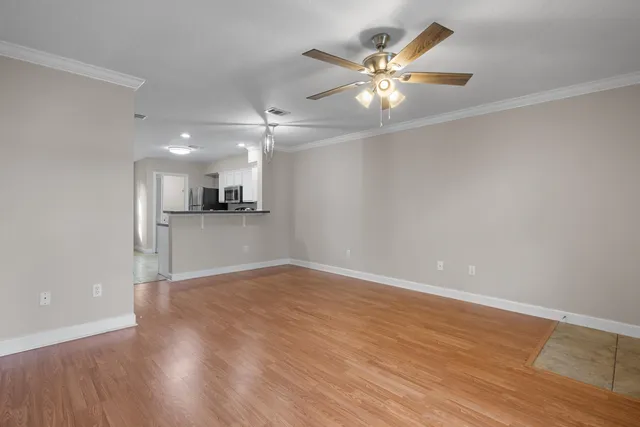 a view of a livingroom with a ceiling fan and wooden floor