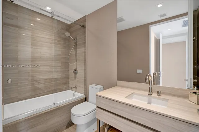 a bathroom with a granite countertop sink toilet and shower