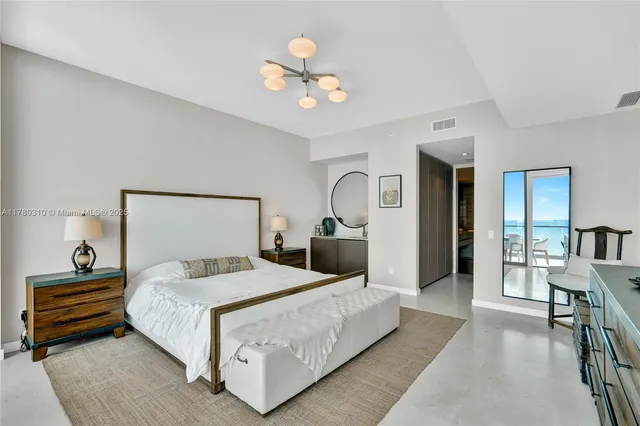 a bedroom with a large bed and a chandelier