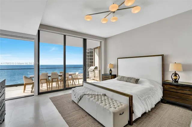 a bedroom with a large bed and a large window with the outer view