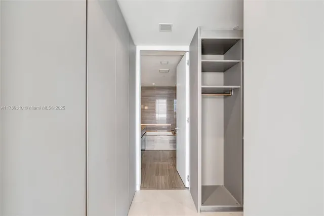 a view of walk in closet with empty racks