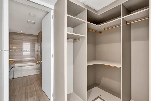 a bathroom with a walk in closet and wooden floor