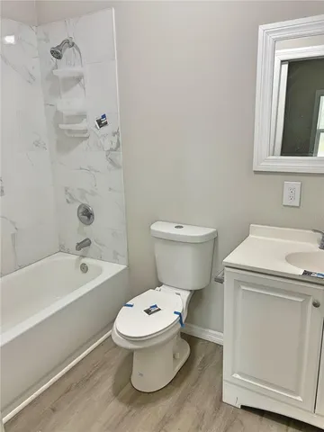 a white toilet sitting next to a bath tub