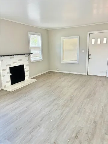 a view of empty room with wooden floor and fireplace