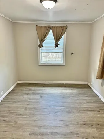 a view of a room with wooden floor and window