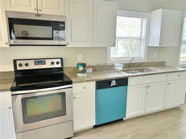 a kitchen with cabinets stainless steel appliances and window