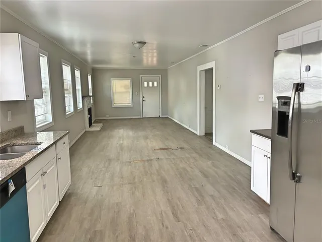 a view of a kitchen with a sink and dishwasher a refrigerator with wooden floor