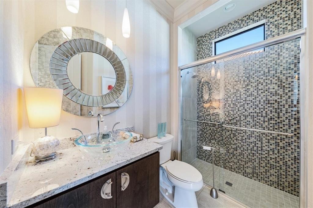 16434 Seneca Way Naples, FL 34110 - Photo 11 of 34 a bathroom with a granite countertop sink a mirror and toilet