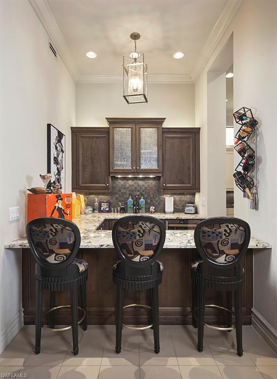 16434 Seneca Way Naples, FL 34110 - Photo 8 of 34 a view of a dining room with furniture and chandelier