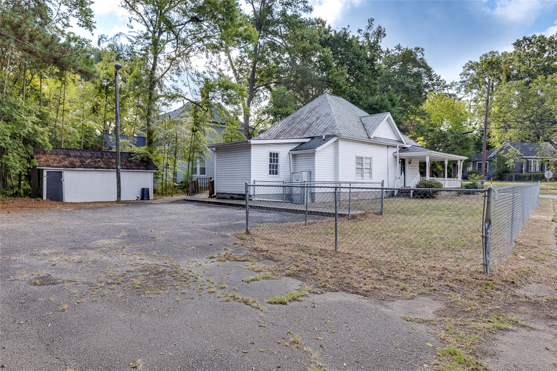 301 Cater Street Anderson, SC 29621 - Photo 26 of 29 Mature trees frame a classic exterior showcasing a wrap-around driveway and fenced lawn.