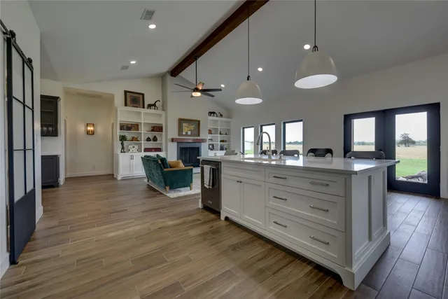 a view of living room kitchen with stainless steel appliances granite countertop room and window