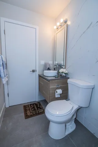 a white toilet sitting next to a bathroom sink