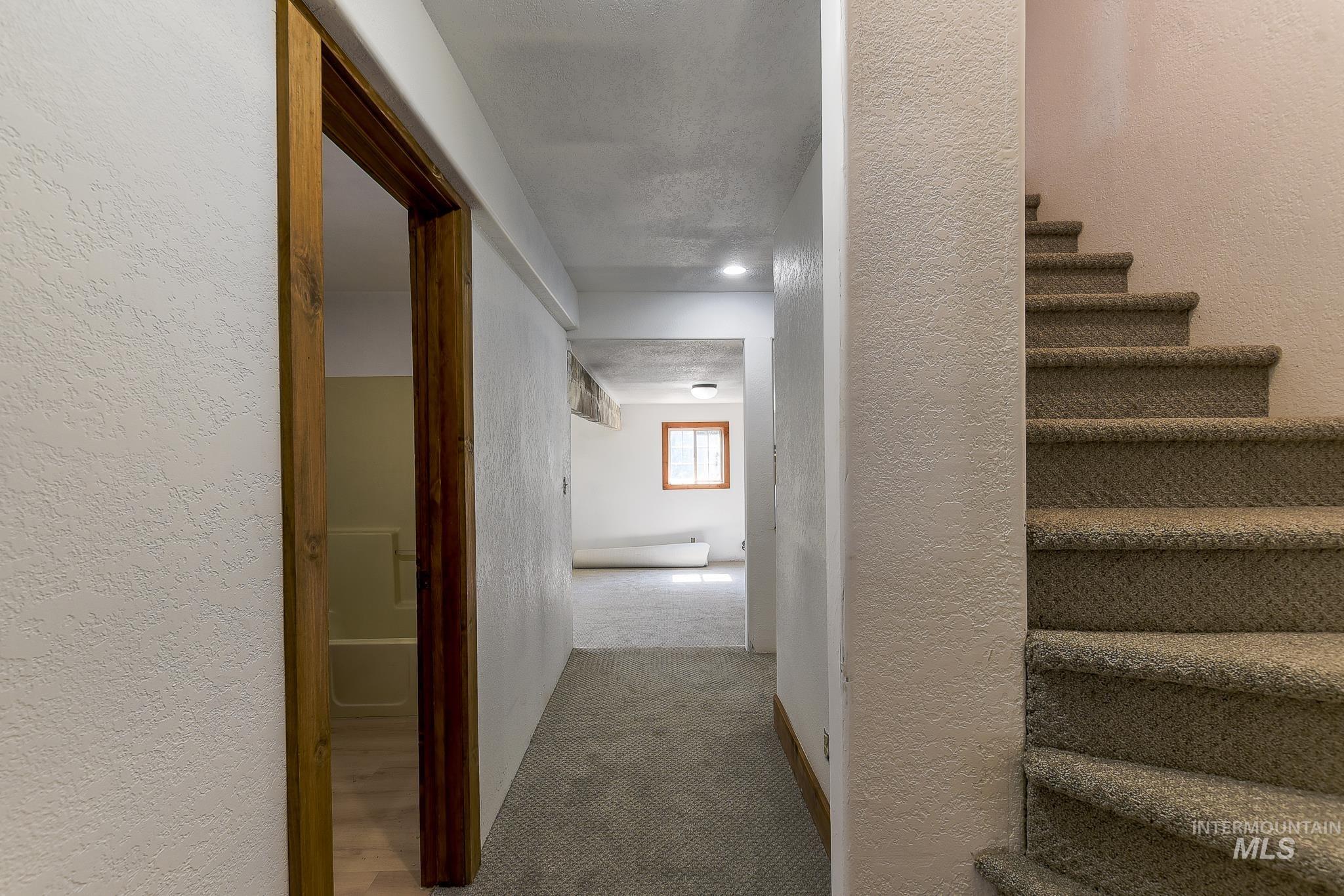 1045 Joyce Road Moscow, ID 83843 - Photo 36 of 50 Carpeted staircase with textured walls, recessed ceiling lighting, and wood-framed doorway