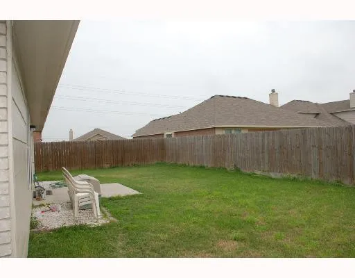 a backyard of a house with table and chairs