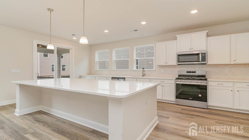 265 Plainfield Road Edison, NJ 08820 - Photo 3 of 3 a kitchen with stainless steel appliances granite countertop a sink stove and microwave
