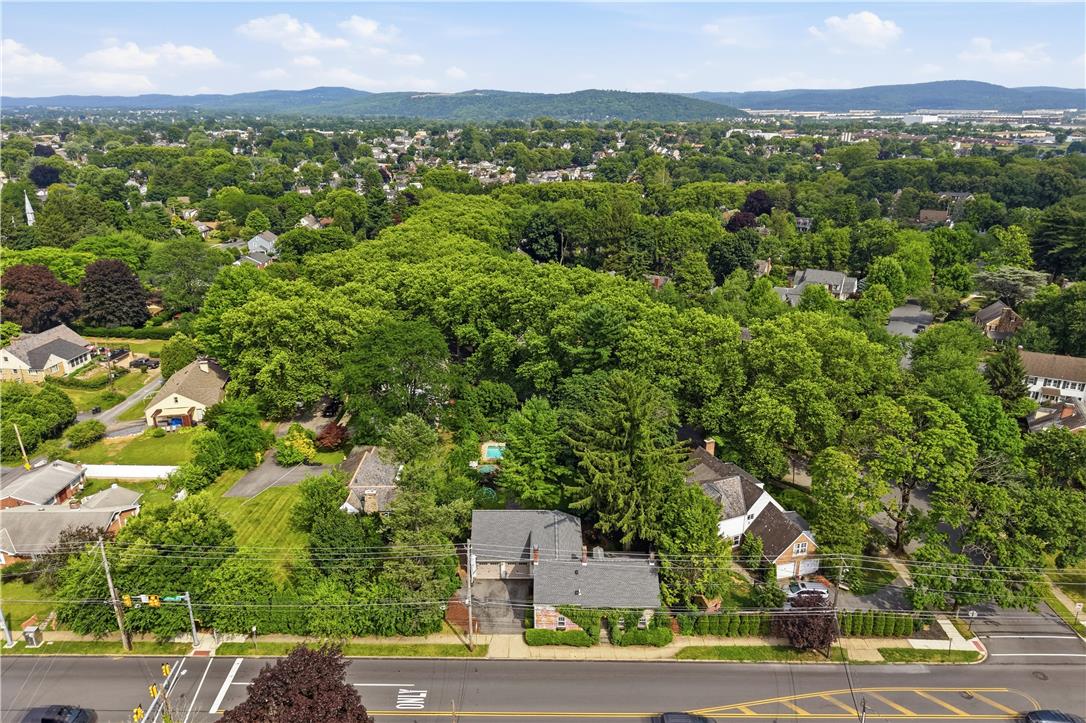 2014 Linden Street Bethlehem, PA 18017 - Photo 79 of 85 An aerial perspective reveals a verdant neighborhood with scattered homes, showcasing expansive tree coverage and distant hills.