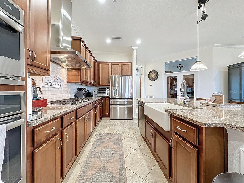 168 Silver Maple Road Groveland, FL 34736 - Photo 20 of 71 a kitchen with stainless steel appliances granite countertop a sink a stove and a refrigerator