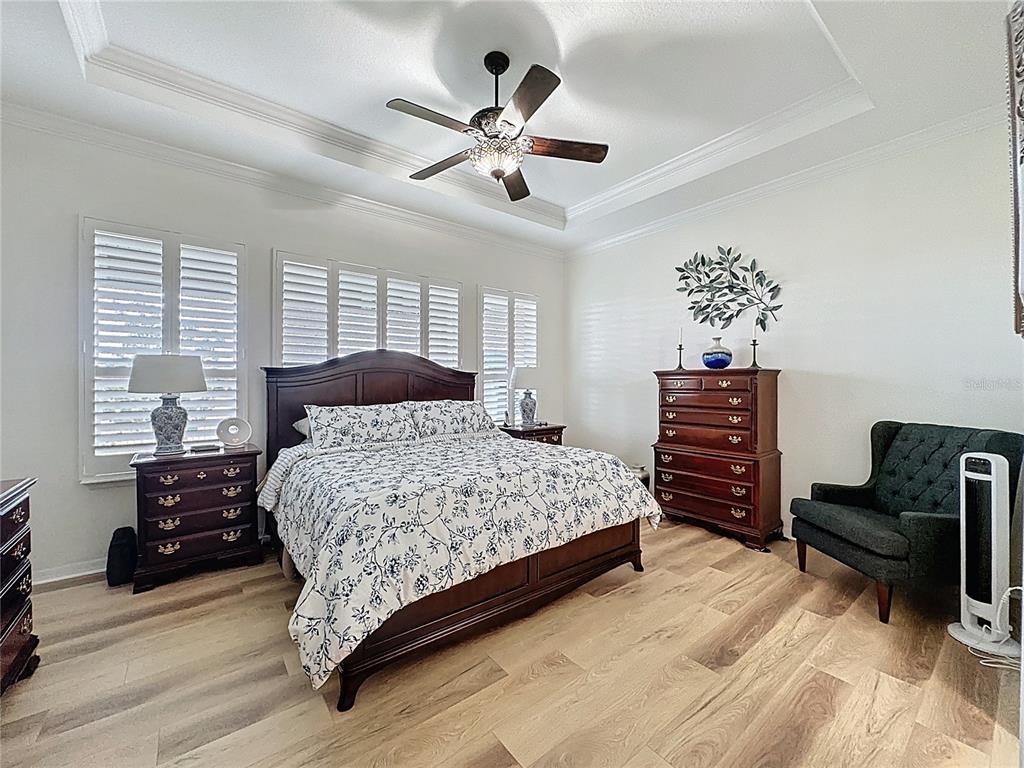 168 Silver Maple Road Groveland, FL 34736 - Photo 34 of 71 a bedroom with a large bed and a chandelier