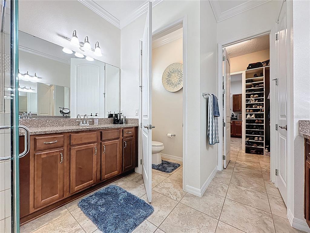168 Silver Maple Road Groveland, FL 34736 - Photo 37 of 71 a spacious bathroom with a granite countertop sink a mirror and a shower