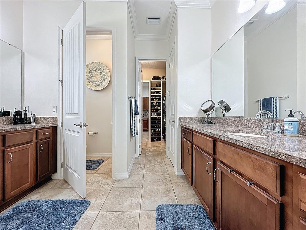 168 Silver Maple Road Groveland, FL 34736 - Photo 38 of 71 a spacious bathroom with a granite countertop sink and a mirror