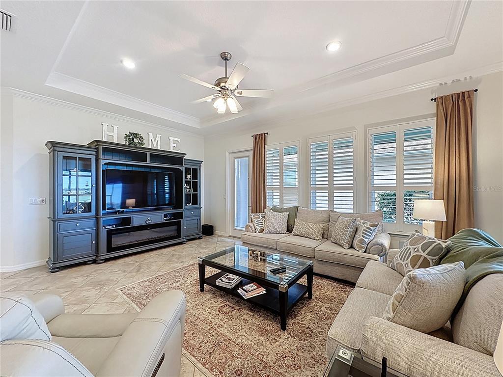 168 Silver Maple Road Groveland, FL 34736 - Photo 8 of 71 a living room with furniture a ceiling fan a flat screen tv and a fireplace