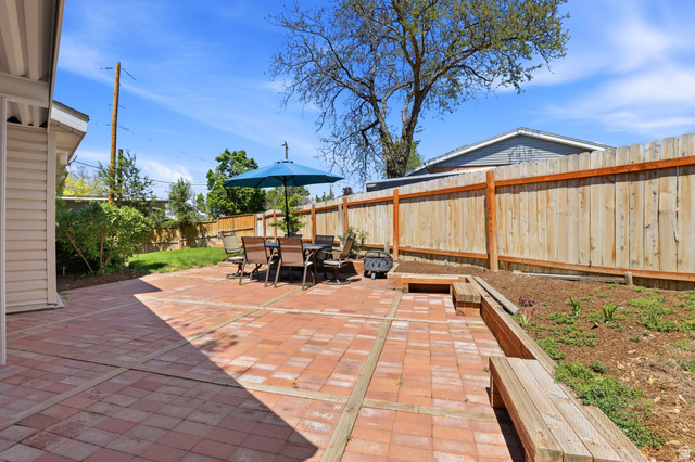 4245 3320 East Holladay, UT 84124 - Photo 38 of 51 Expansive brick paver patio featuring a built-in wooden bench and a privacy fence